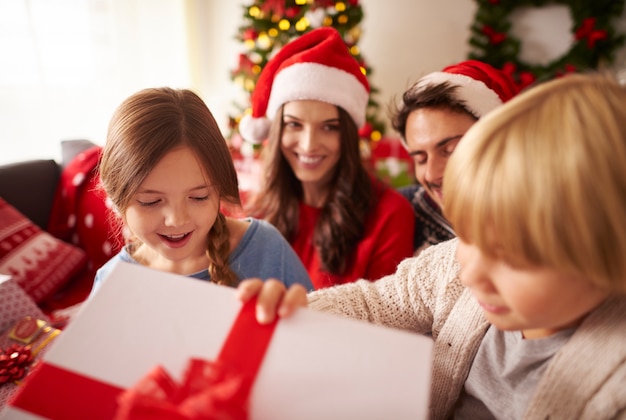 Bambini felici che aprono i regali di Natale