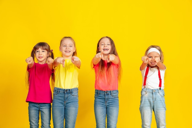 Bambini felici che giocano e si divertono insieme sulla parete gialla