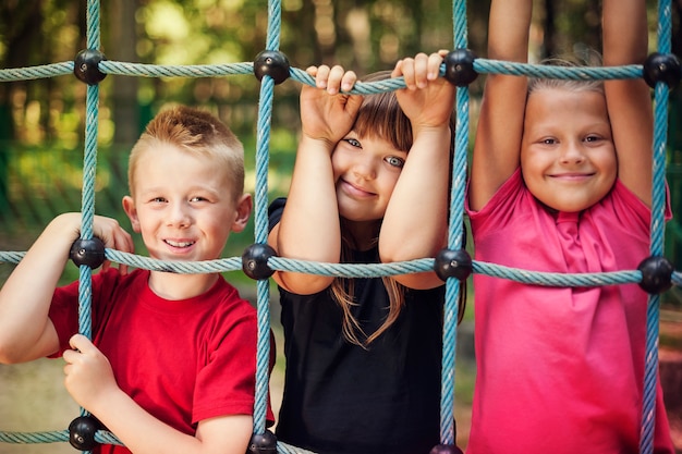 Bambini felici che tengono una rete sul campo da giuoco