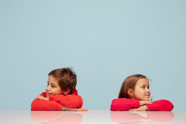 Bambini felici isolati su sfondo blu studio Guarda felice allegro sincero Copyspace Concetto di emozioni di educazione dell'infanzia