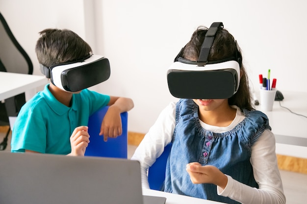 Bambini irriconoscibili che giocano e utilizzano l'auricolare VR