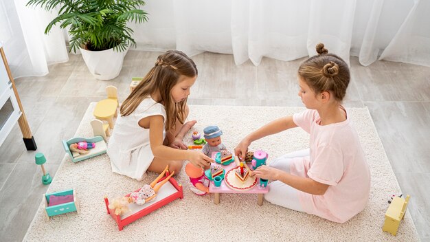 Bambini non binari che giocano a un gioco di compleanno con una baby doll