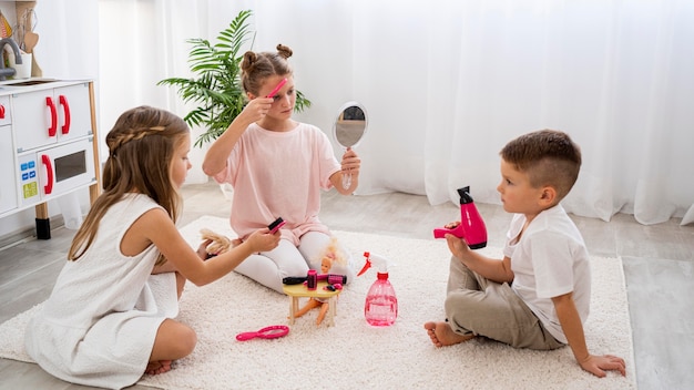 Bambini non binari che giocano a un gioco di salone di bellezza