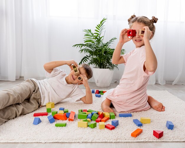 Bambini non binari che giocano con giochi colorati