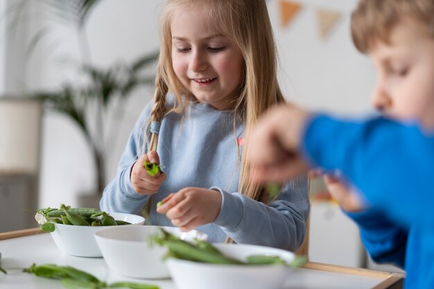 Bambini piccoli di vista laterale che giocano con i fagioli