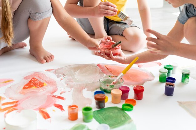 Bambini ravvicinati che dipingono in squadra