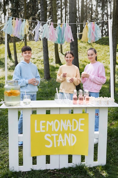 Bambini sorridenti a tutto campo con limonata