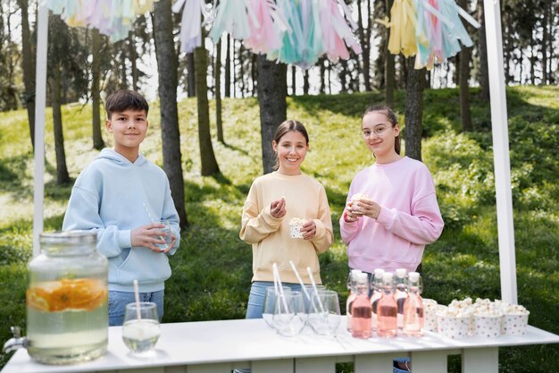 Bambini sorridenti di tiro medio con limonata