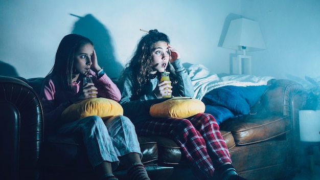 Bambini spaventati con succo guardando la TV