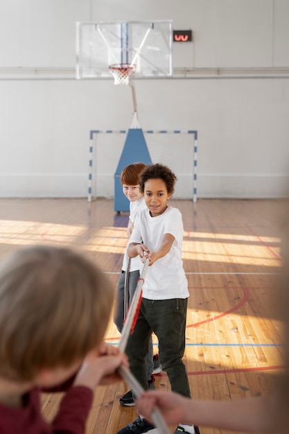 Bambini sportivi che tirano la corda in palestra