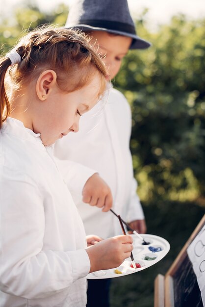 Bambini svegli che dipingono in un parco