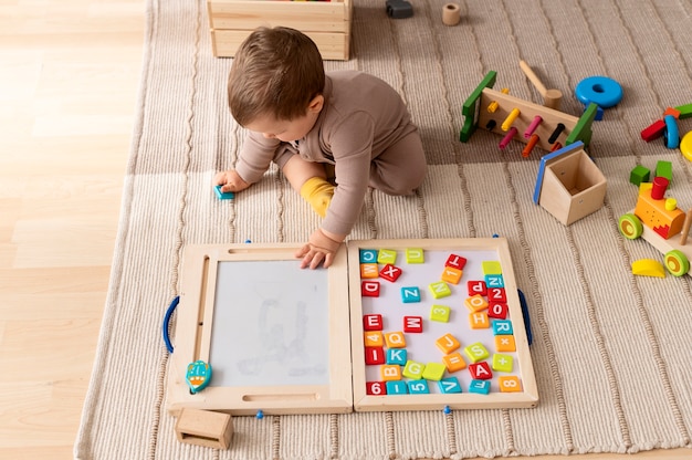 Bambino a tutto campo che gioca con giocattoli di legno colorati