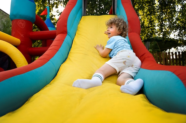 Bambino a tutto campo che gioca nella casa di rimbalzo