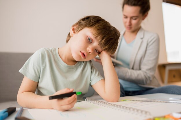 Bambino annoiato a casa mentre viene istruito