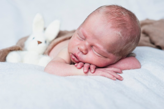 Bambino assonnato con coniglio giocattolo