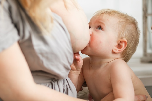 Bambino biondo che allatta al seno. Ritratto di testa di Close-up