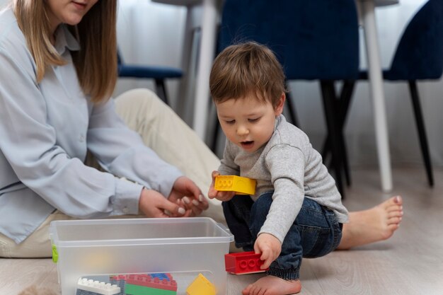 Bambino carino che gioca con i giocattoli a casa