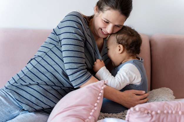 Bambino carino che tira sua madre per abbracciarlo