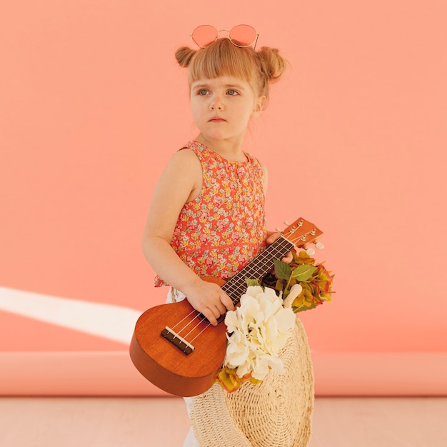 Bambino carino in posa con la chitarra