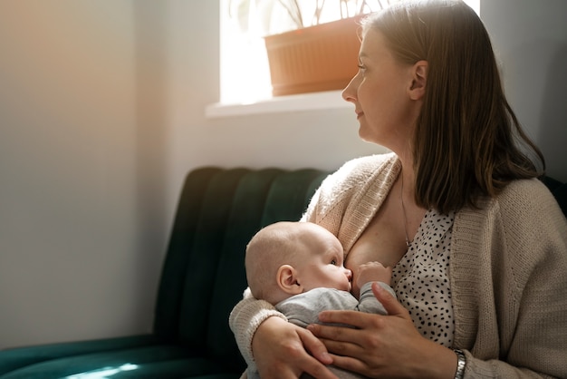 Bambino che allatta al seno donna vista laterale