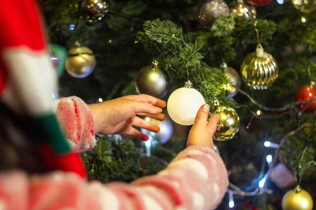 Bambino che decora il bellissimo albero di Natale
