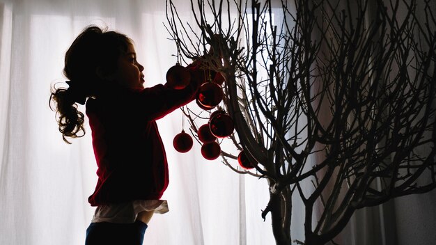 Bambino che decora l&#39;albero di Natale