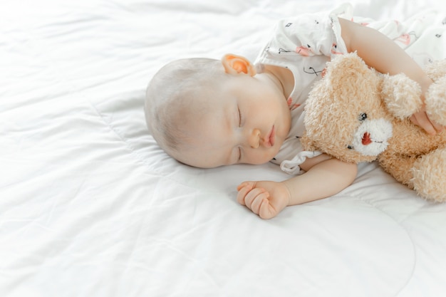 Bambino che dorme con un orsacchiotto