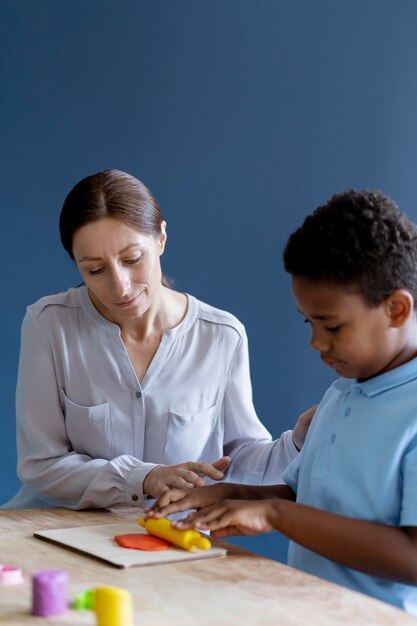 Bambino che fa una sessione di terapia occupazionale con uno psicologo