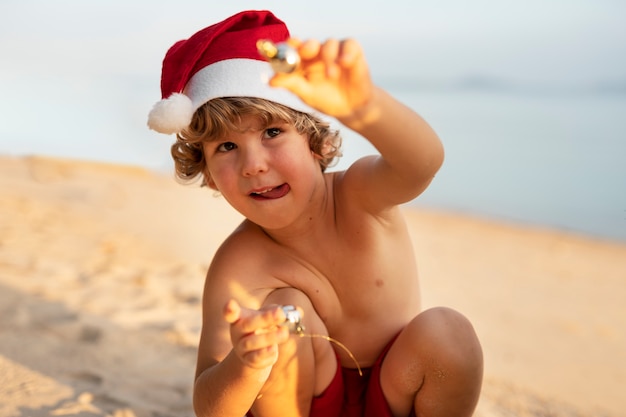 Bambino che festeggia il Natale a luglio