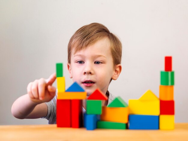 Bambino che gioca con diverse forme colorate