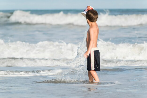 Bambino che gioca sul litorale in acqua
