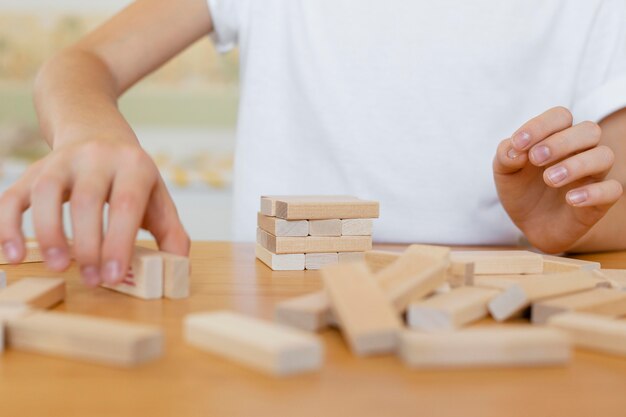 Bambino che gioca un primo piano del gioco della torre di legno
