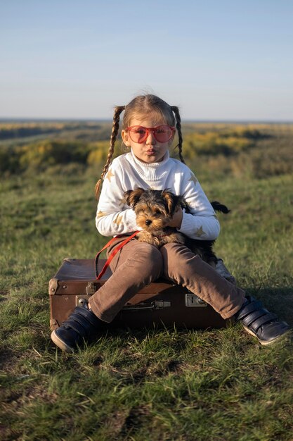 Bambino che indossa occhiali da sole che giocano con il suo cane