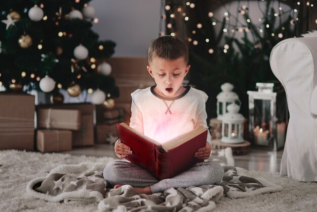 Bambino che legge un libro incantato