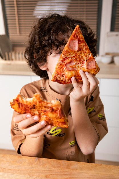 Bambino che mangia pizza a casa