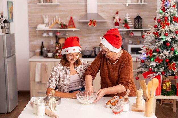 Bambino che mescola gli ingredienti dei biscotti in una ciotola per fare un impasto tradizionale fatto in casa