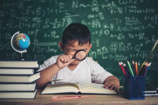 bambino che osserva o studia il modello educativo del globo in classe.