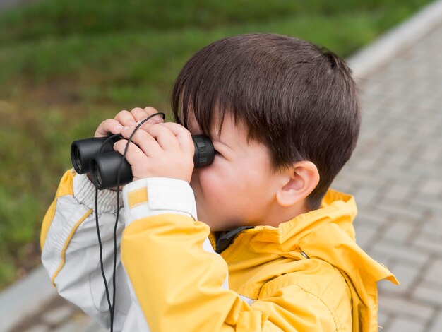 Bambino che osserva tramite il binocolo