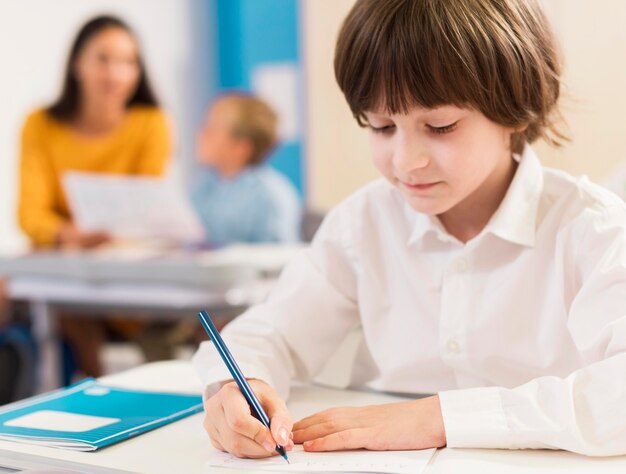 Bambino che scrive nel suo taccuino durante la lezione