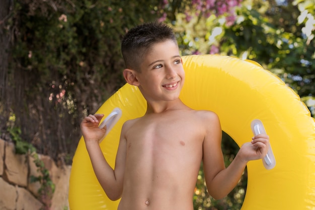 Bambino che si diverte con galleggiante a bordo piscina