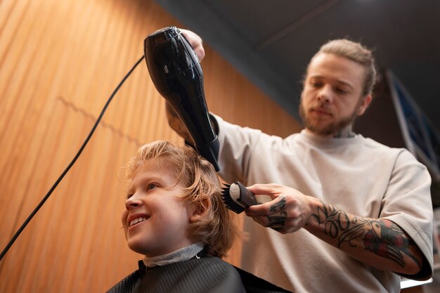 Bambino che si fa soffiare i capelli al salone