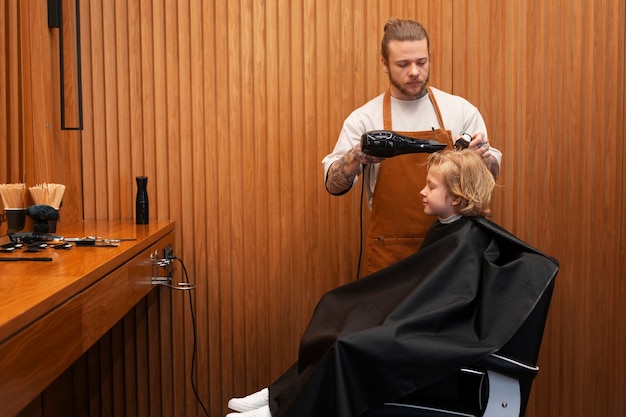 Bambino che si fa soffiare i capelli al salone