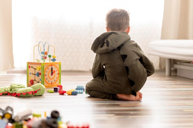 Bambino con il costume che gioca a casa