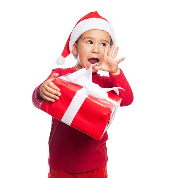 Bambino con la bocca aperta in possesso di un regalo