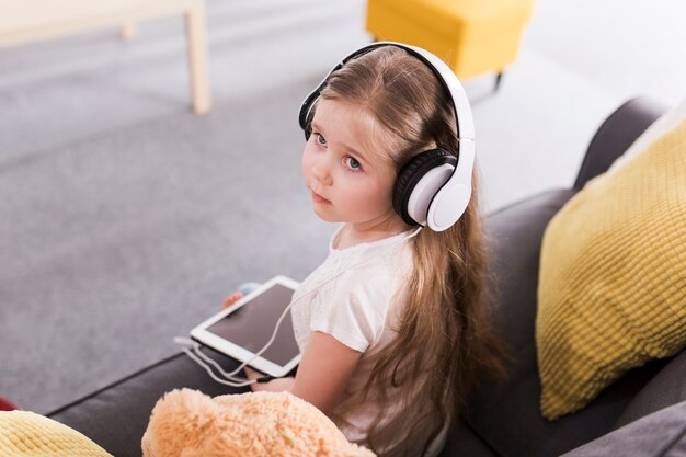 Bambino con tablet e cuffie