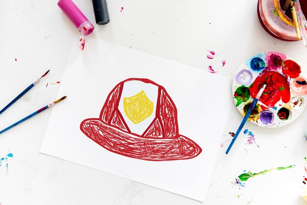 Bambino con un disegno del casco del pompiere