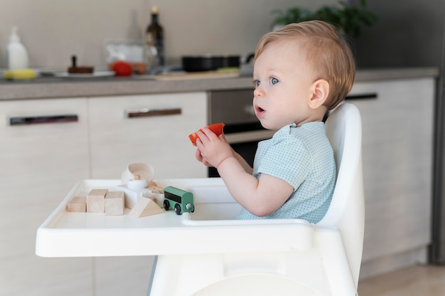 Bambino del colpo medio che mangia pomodoro