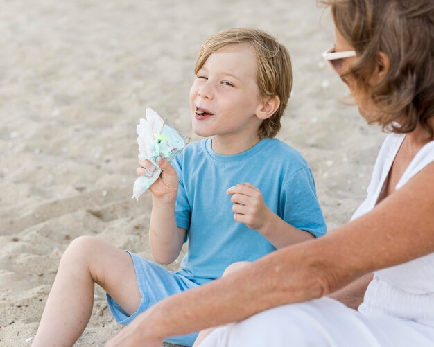 Bambino del primo piano che mangia i semi sulla spiaggia