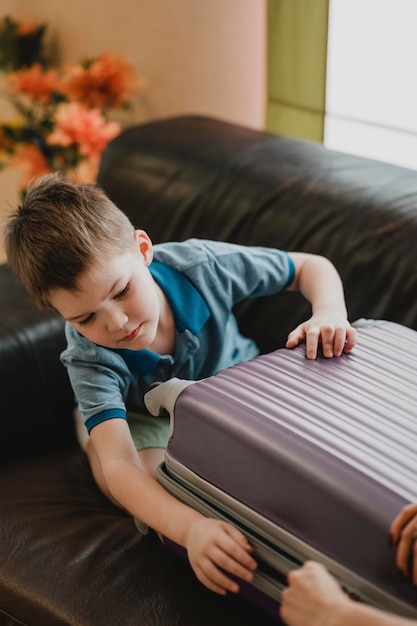 Bambino del primo piano che prepara i bagagli