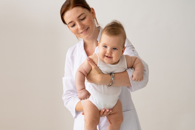 Bambino della holding del medico di smiley di vista frontale